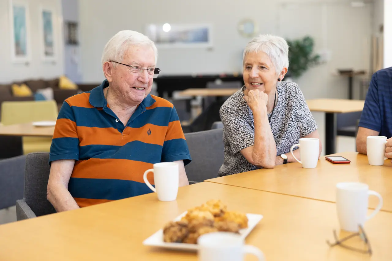 Elderly couple having coffee and biscuits